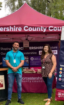 Two staff members stand in front of the WCC gazebo at a Resident Roadshow