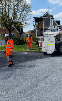 Contractors resurfacing a road