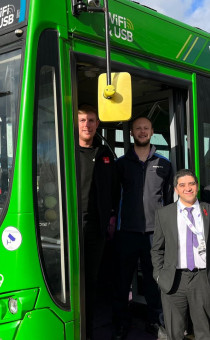 Guests pose on one of the new buses