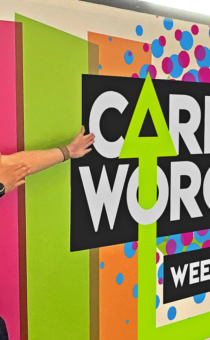 A member of staff highlighting the Careers Worcs Week 2025 sign.